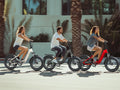 Trois cyclistes roulant ensemble en ville sur des fat bikes électriques pliables